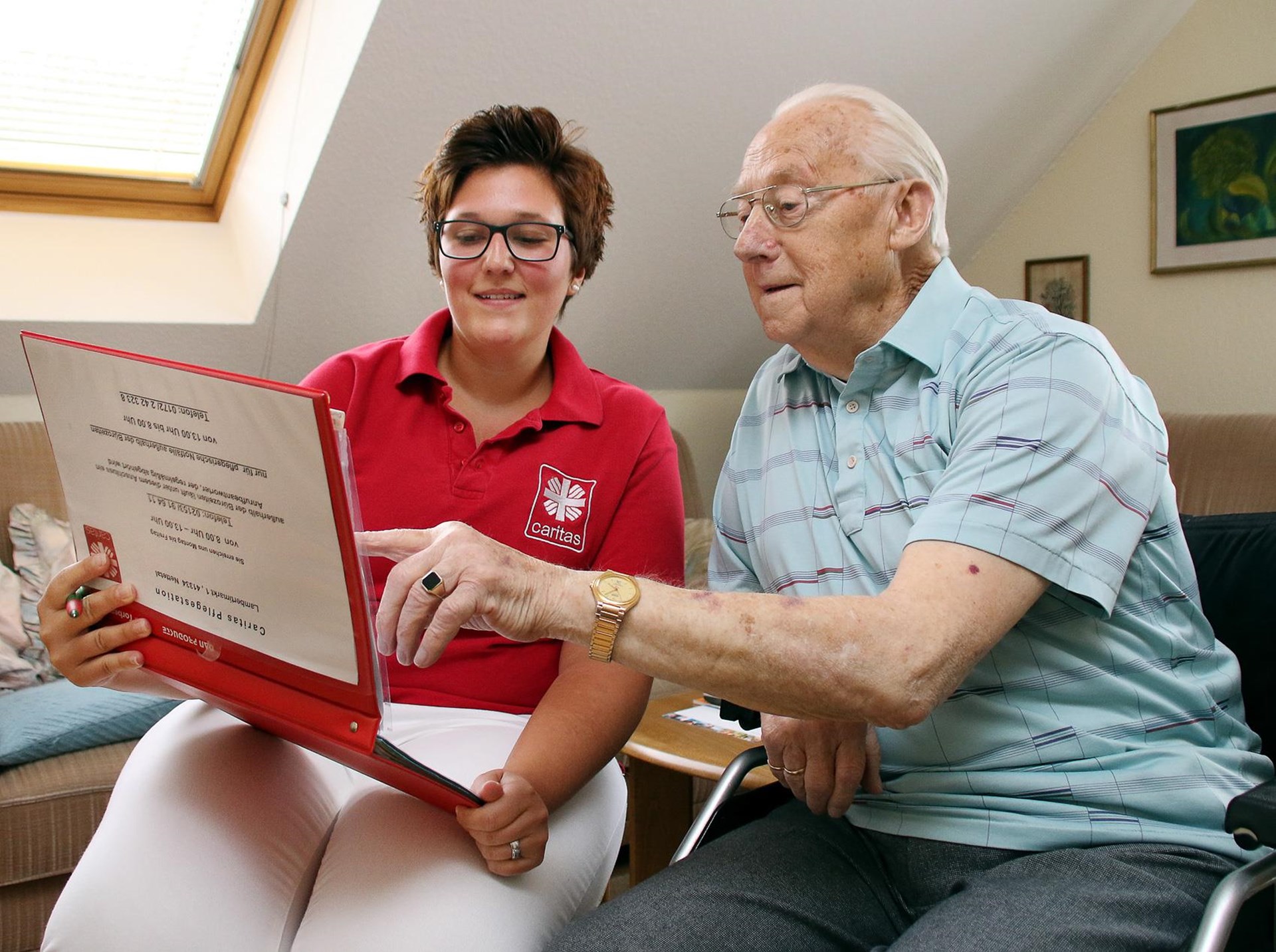 Caritas-Mitarbeiterin im Gespräch mit einem Patienten