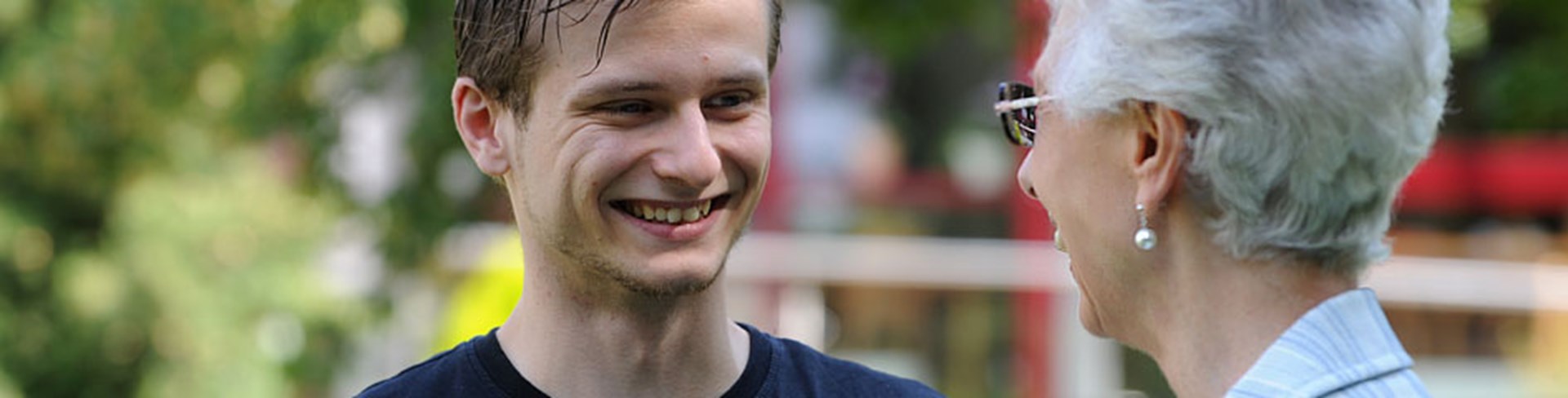 Caritas-Mitarbeiter im Gespräch mit einer alten Dame